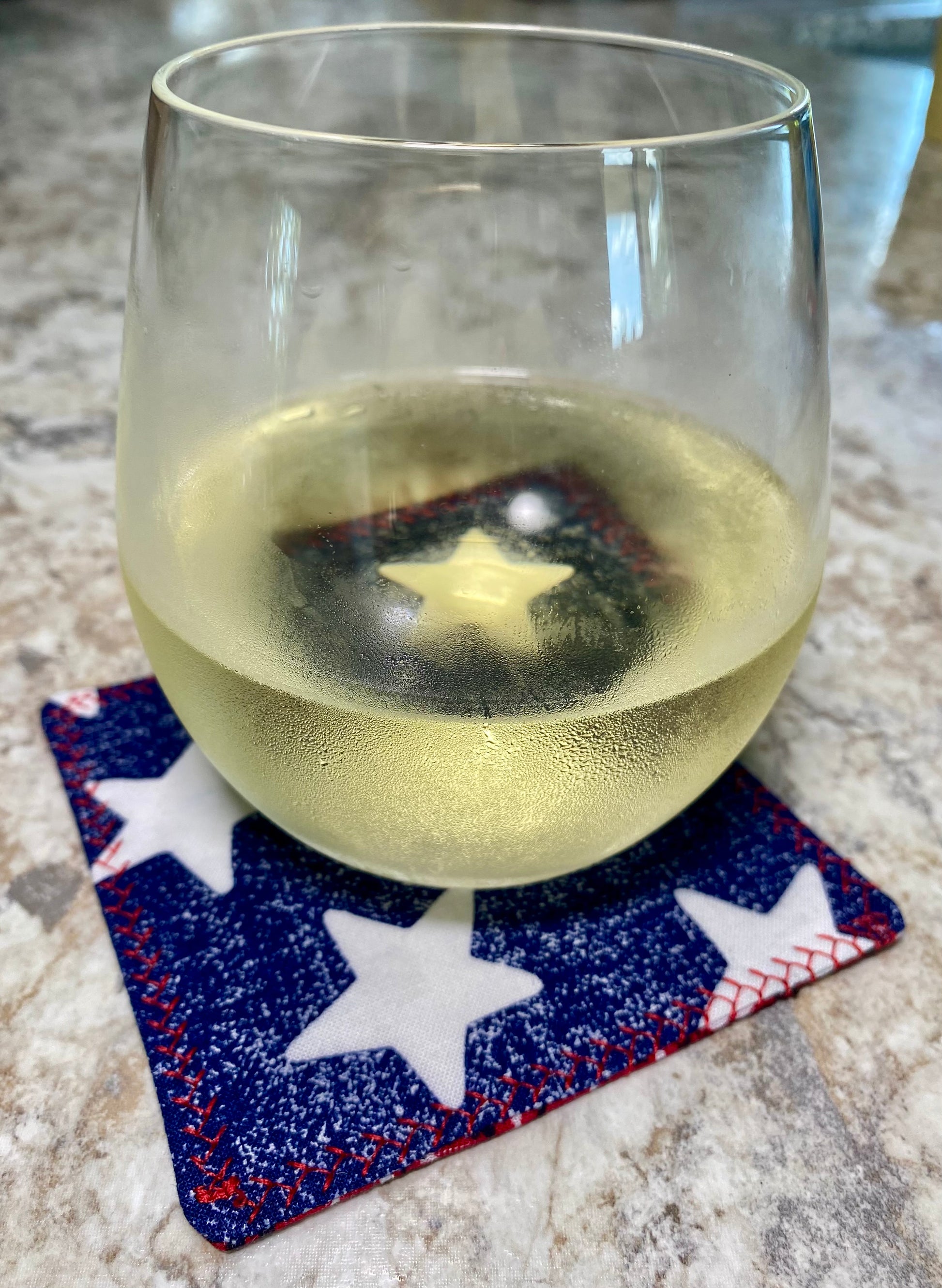 Clear glass with white liquid on a star-patterned coaster