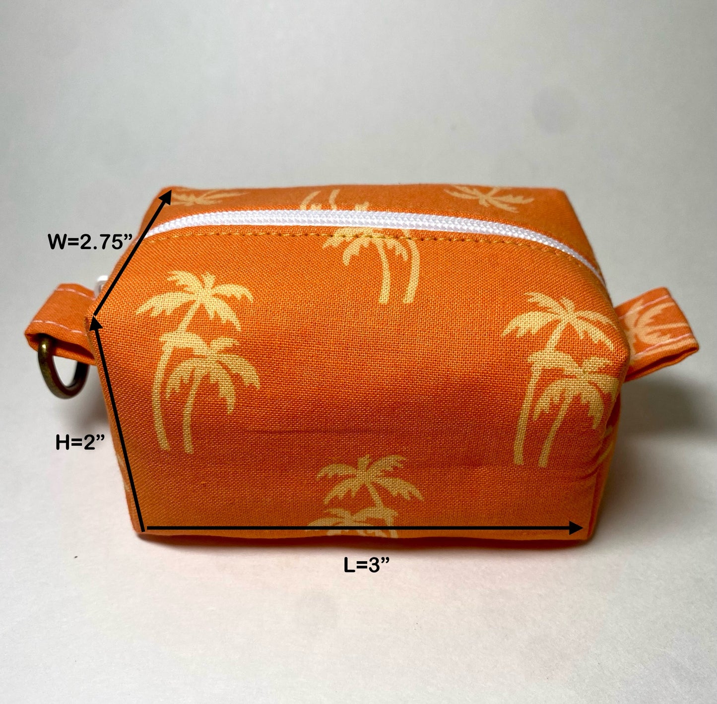 Orange pouch with gold palm tree pattern.