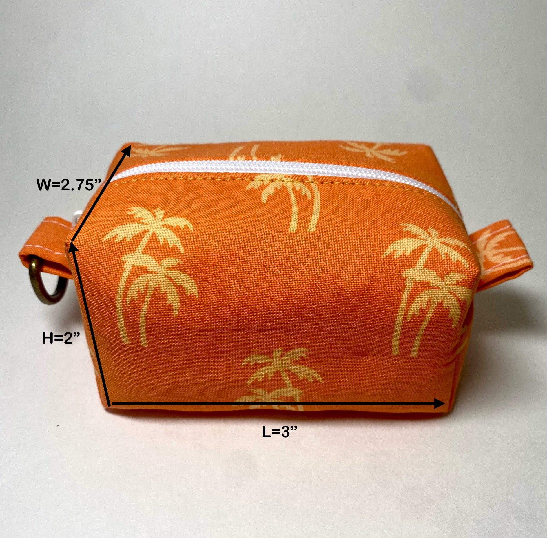 Orange pouch with gold palm tree pattern.